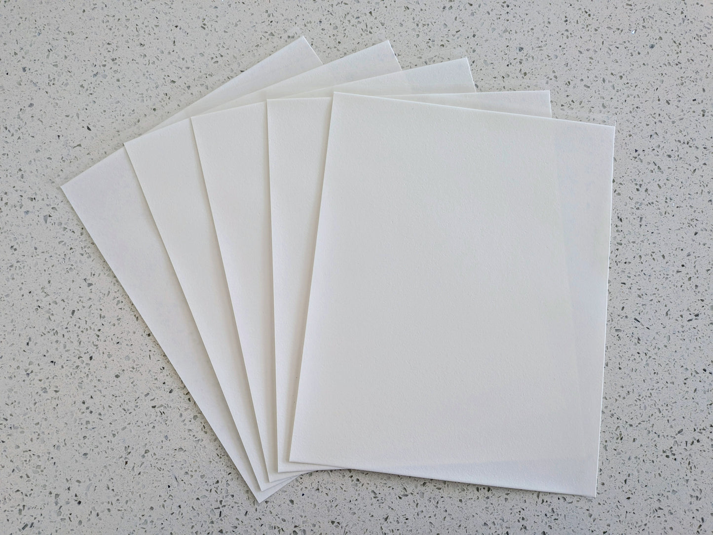 Edible icing paper sheets on a gray speckled surface
