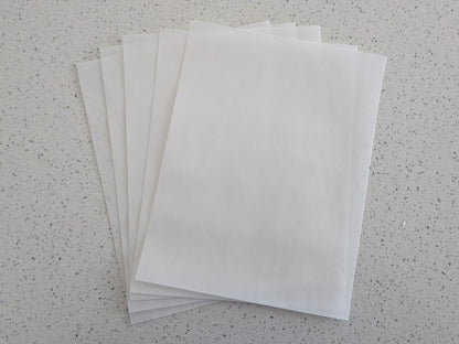 Stack of edible wafer paper sheets on a speckled gray surface
