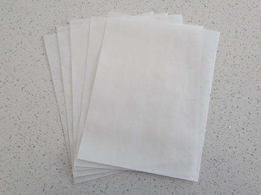 Stack of edible wafer paper sheets on a speckled gray surface