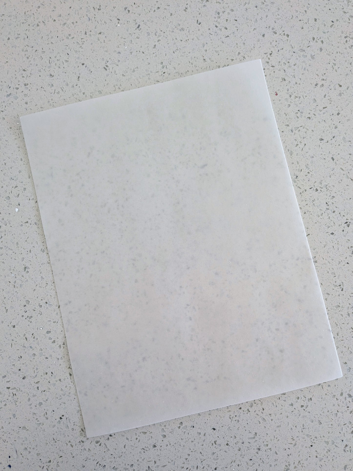 Edible wafer paper on a speckled gray surface