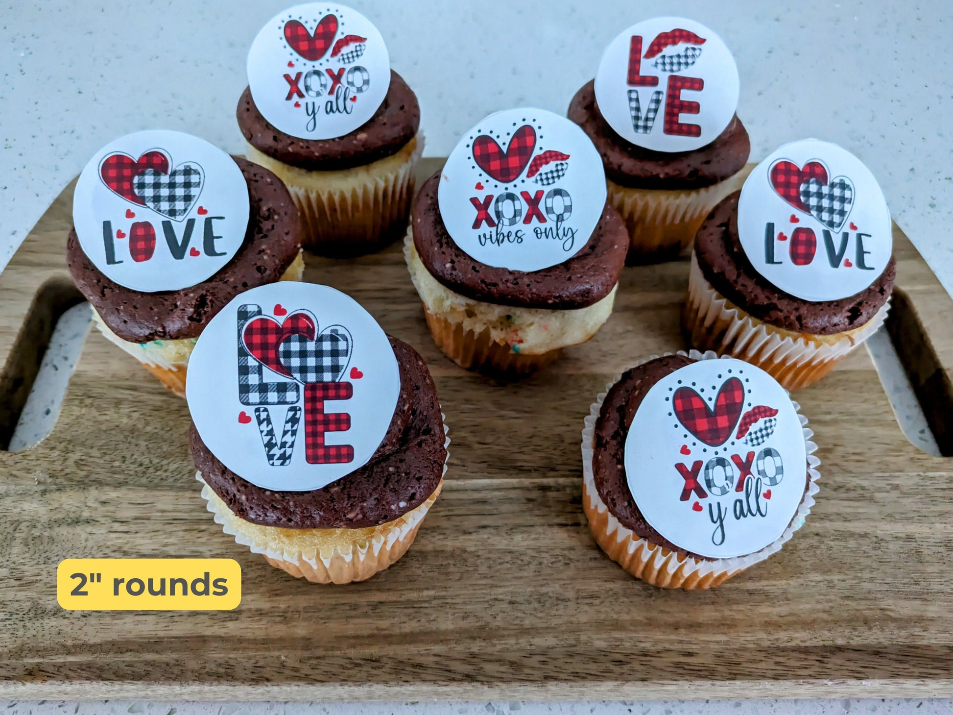 Cupcakes with decorative toppers on a wooden board