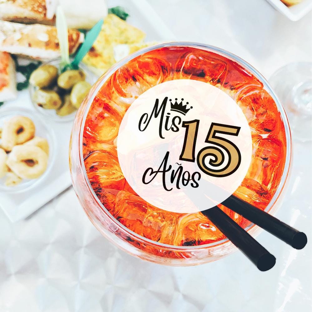 Drink garnish topper with 'Mis 15 Años' text on a table with snacks