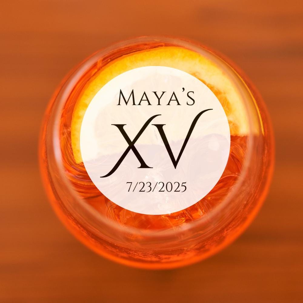 Edible drink topper with 'MAYA'S XV 7/23/2025' text on an orange background