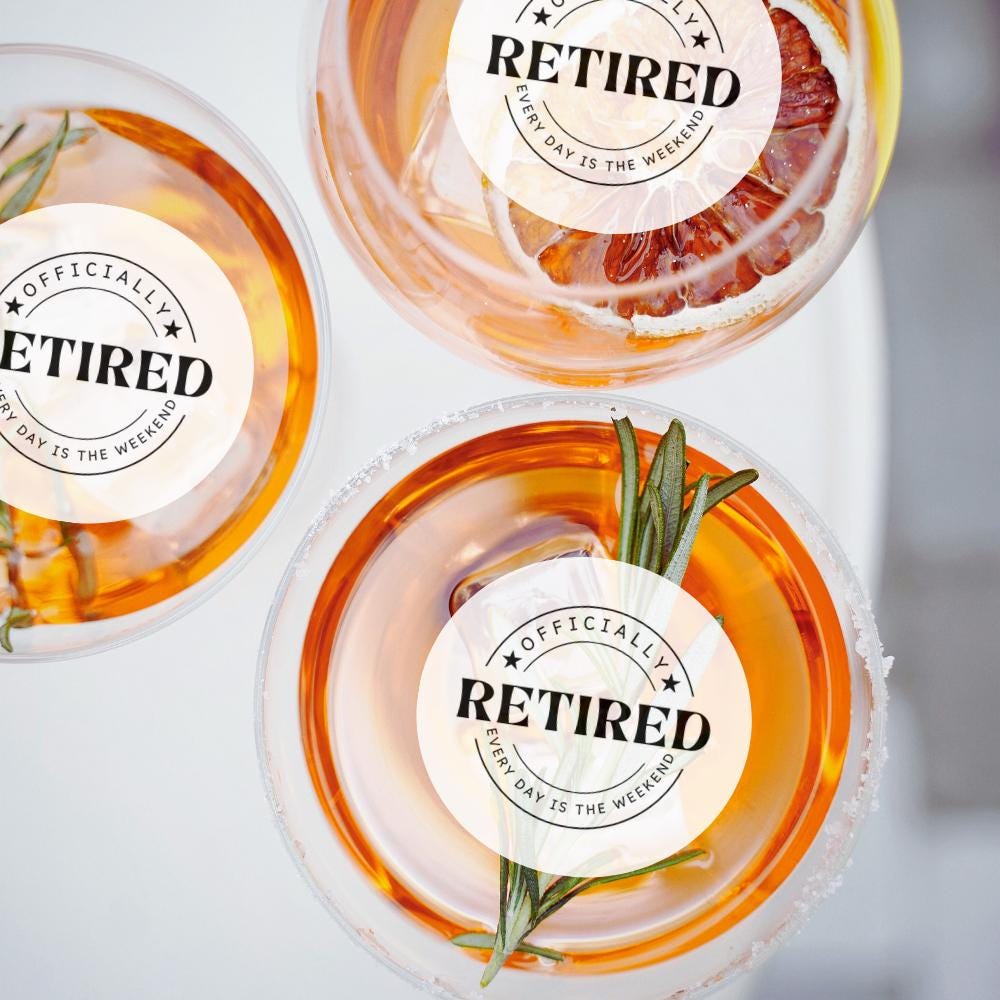 Three glasses with a 'Retired' edible cocktail garnish and rosemary garnish on a light background