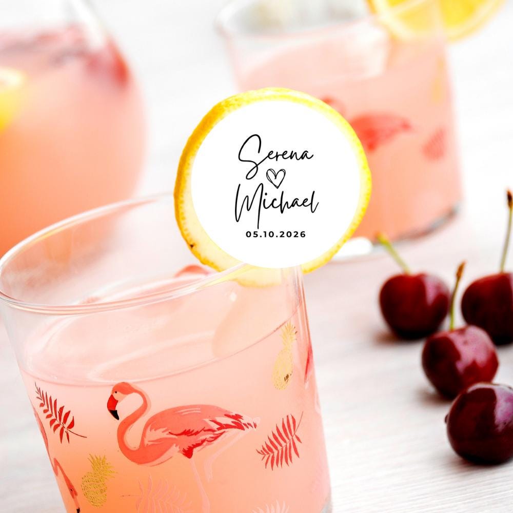 Pink drink with flamingo design, cherry, and personalized edible drink topper on a white background