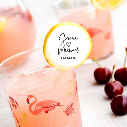 Pink drink with flamingo design, cherry, and personalized edible drink topper on a white background