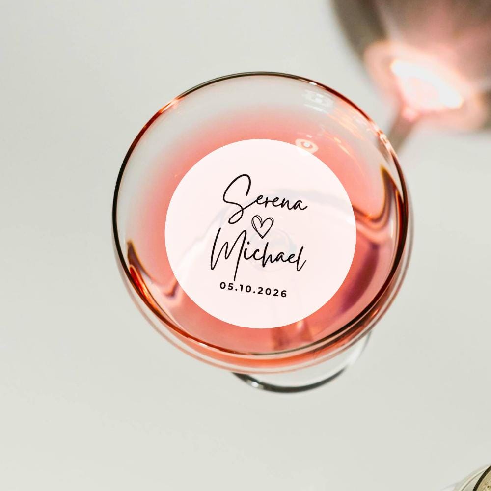 Rose gold wine glass with a personalized edible drink garnish on a light background