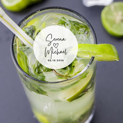 Green drink with lime slices and a straw, featuring a personalized edible wedding sticker on a dark background.