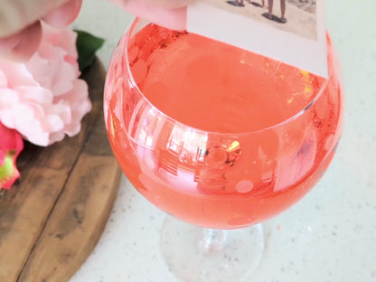 A video of a custom edible image drink topper with a photograph printed on it, placed on a glass filled with a cocktail beverage